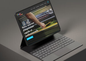 Tablette allumée montrant le site de GRAPHIC UNION, sur une table en métal.